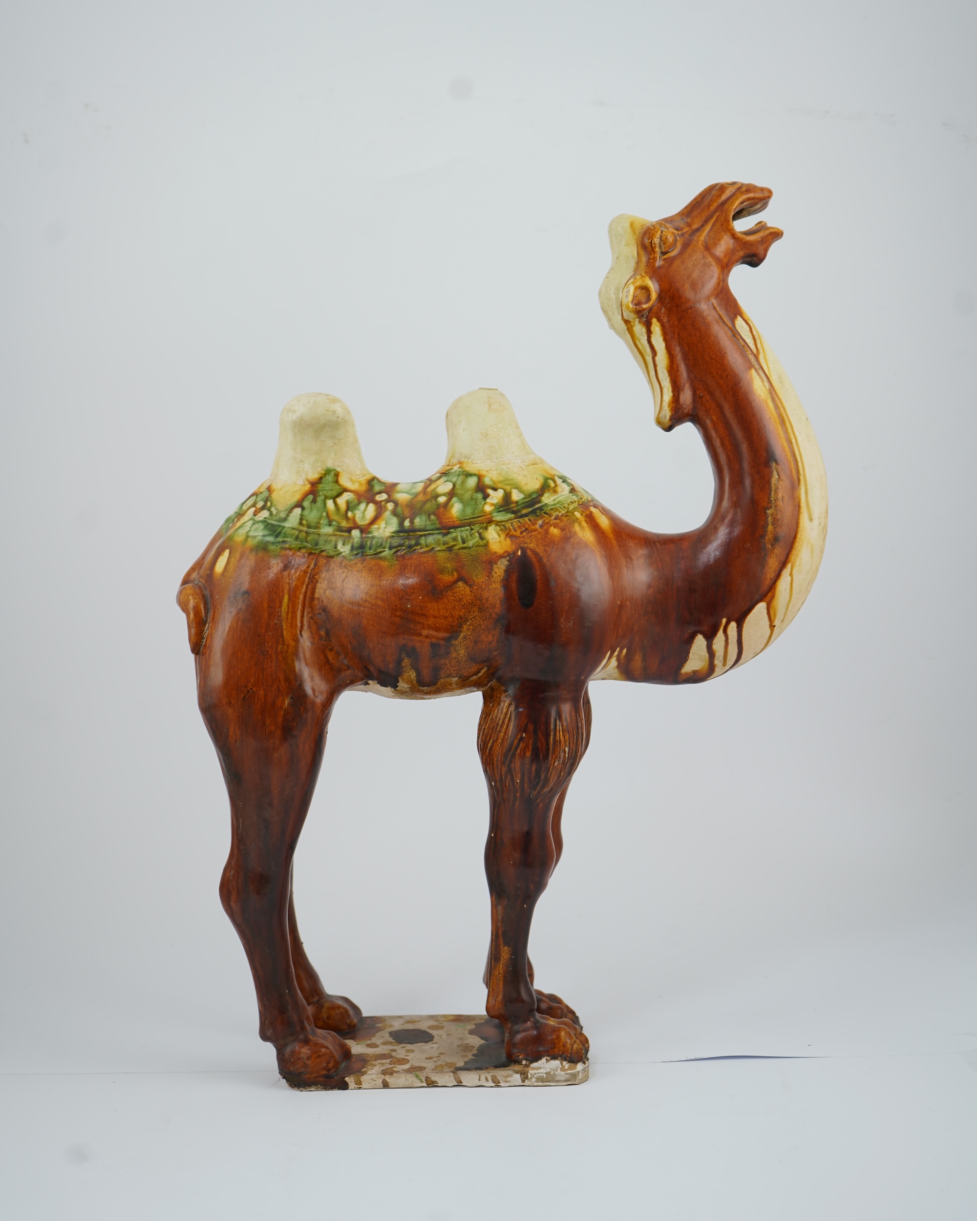 A large Chinese sancai pottery figure of a bactrian camel, Tang dynasty
